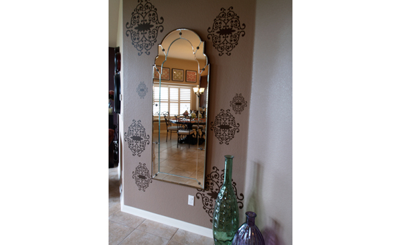 Accent wall off entry, family room-chocolate iron vine Blik wall decals surrounding Moorish inspired decorative wall mirror, and overisze  green and purple glass floor vases in Austin.