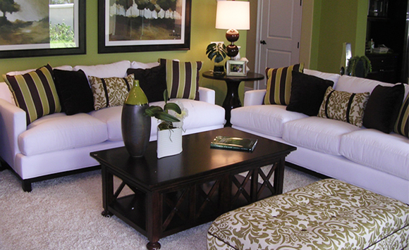 A bright open family room design with white sofas with custom pillow and ottoman design.